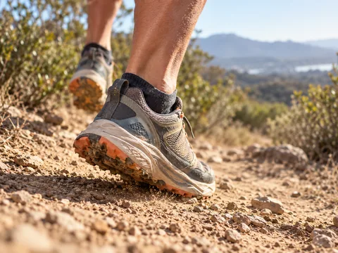 Ankle and foot on a bright trail, face out of frame