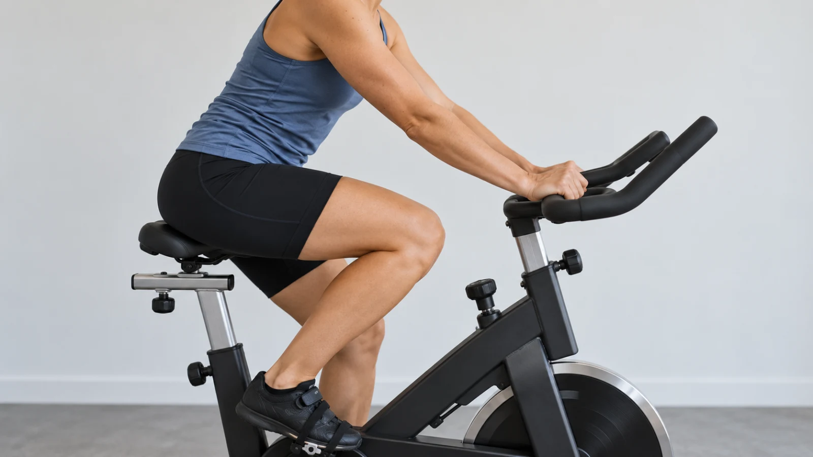 A woman pedaling a stationary bike in a bright studio.